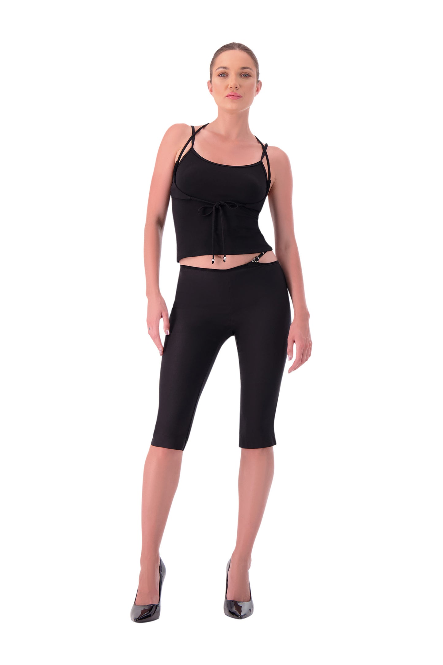Woman wearing a black sleeveless top and black capri leggings on a white background