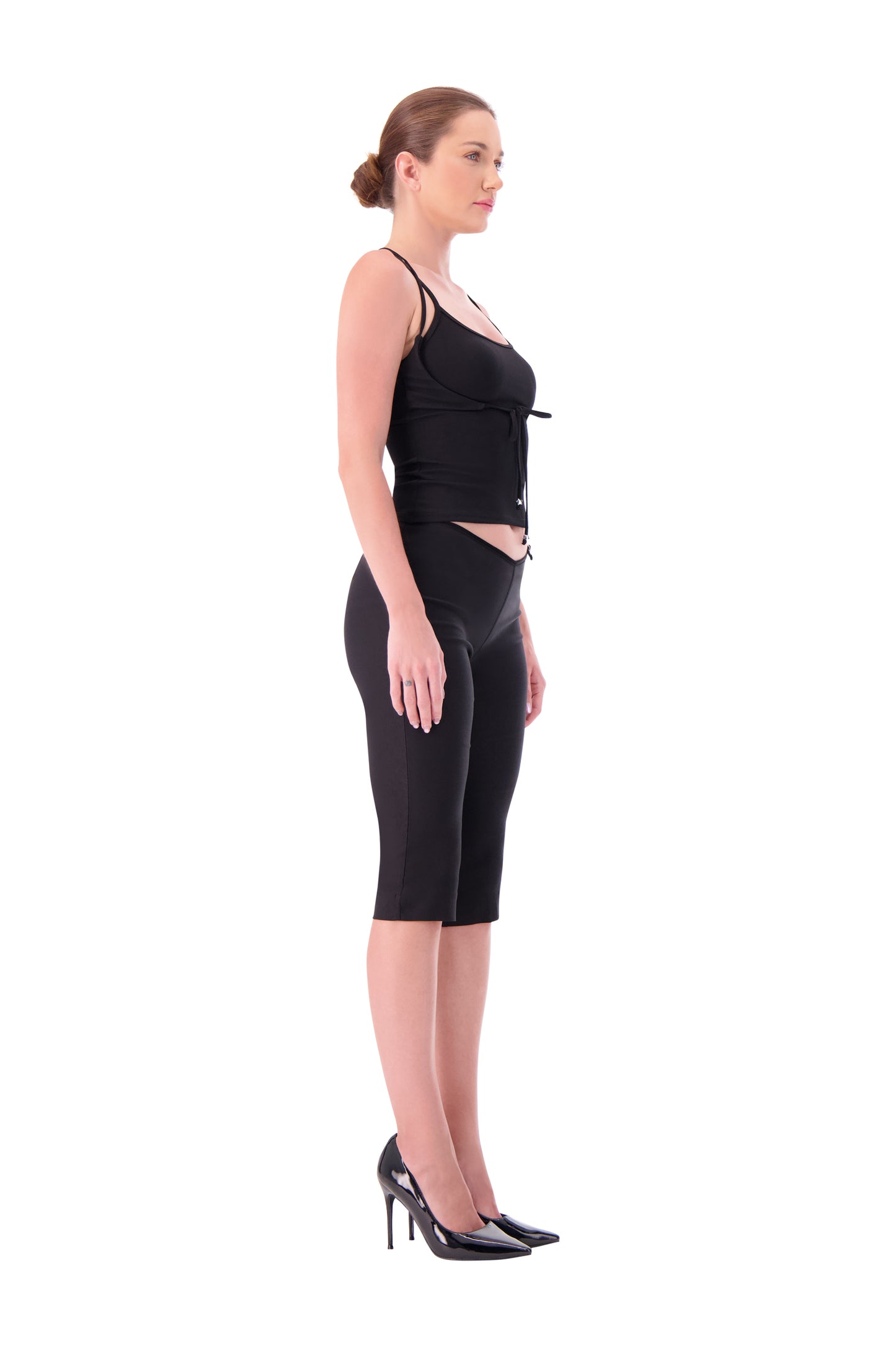 Woman wearing a black sleeveless top and black capri pants on a white background