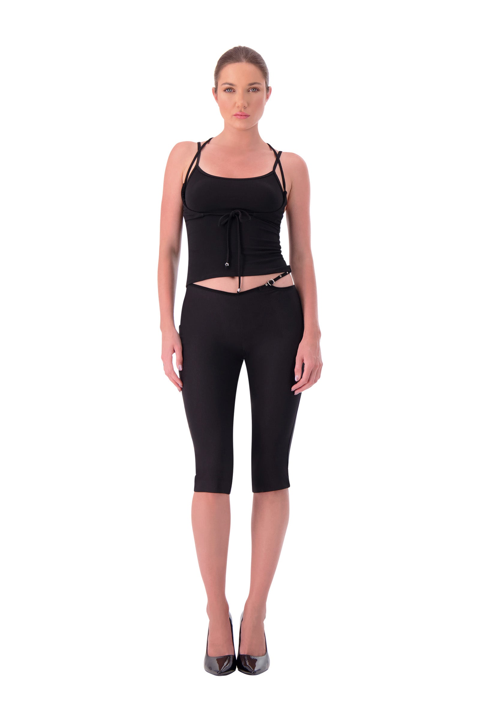 Woman wearing a black sleeveless top and capri pants on a white background