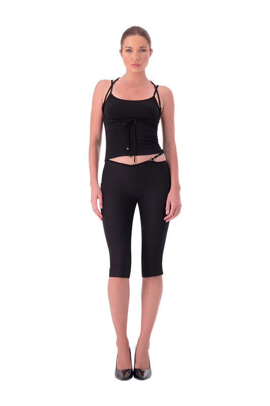 Woman wearing a black sleeveless top and capri pants on a white background